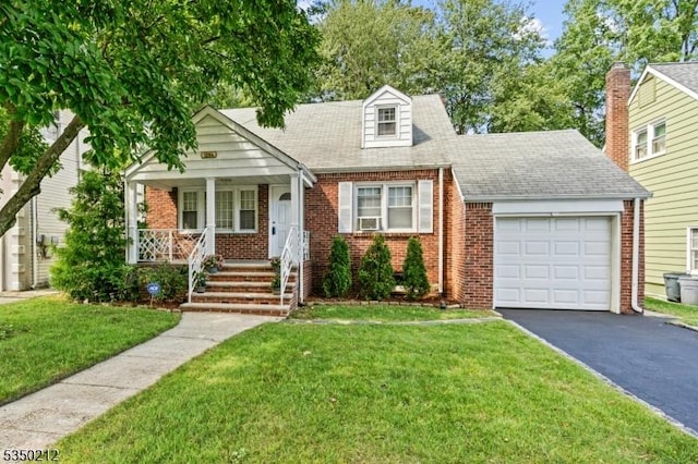 new england style home featuring an attached garage, covered porch, aphalt driveway, brick siding, and a front lawn