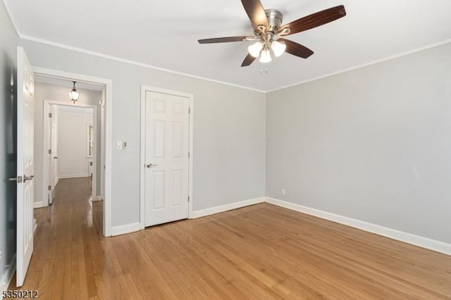 unfurnished bedroom with light wood-style floors, baseboards, and ornamental molding