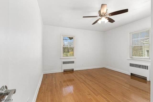 unfurnished room featuring crown molding, radiator heating unit, and a wealth of natural light