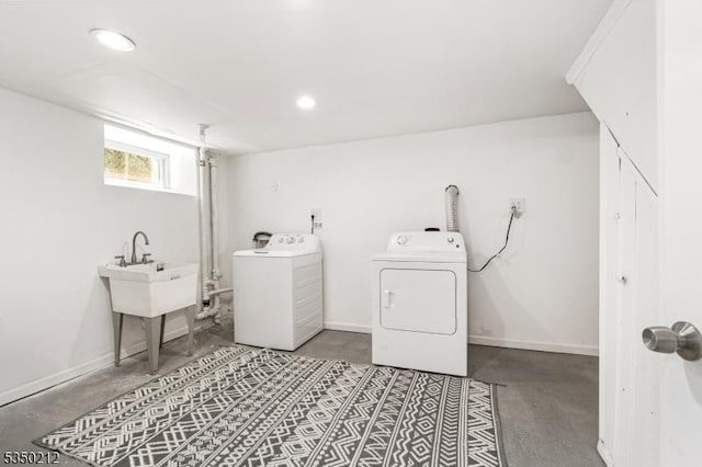 laundry area with recessed lighting, separate washer and dryer, baseboards, and a sink