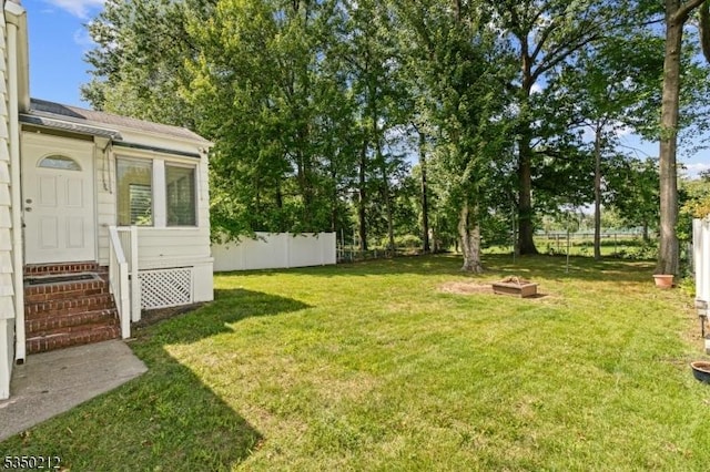 view of yard featuring entry steps and fence