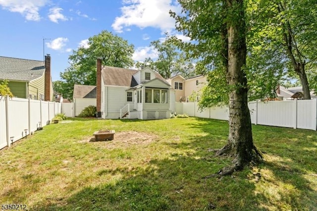 view of yard with a fire pit and a fenced backyard