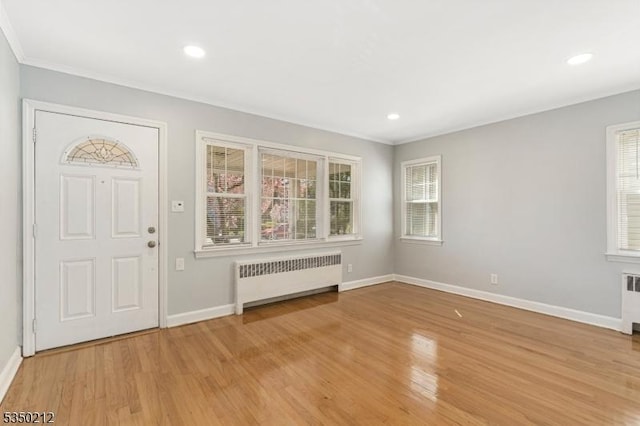 entryway featuring light wood-style flooring, radiator, baseboards, and a wealth of natural light