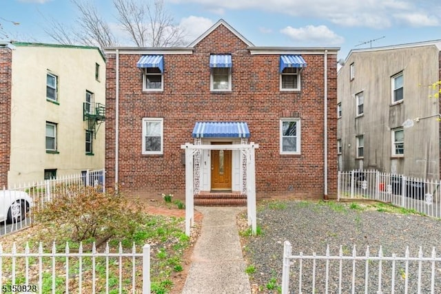 view of front of home featuring fence and brick siding