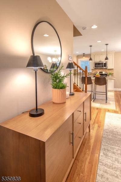 corridor featuring recessed lighting, light wood finished floors, and stairs