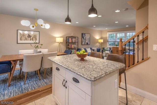 kitchen featuring white cabinetry, an inviting chandelier, hanging light fixtures, and a center island