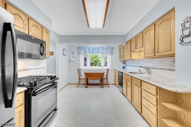 kitchen featuring black appliances, a sink, light brown cabinetry, and tasteful backsplash