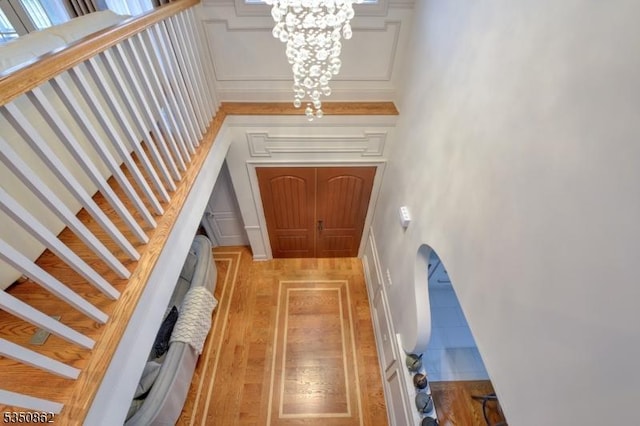 1 Dock Watch Hollow Rd, Warren Twp, NJ 07059 - doorway to outside with a chandelier, light wood-style flooring, stairway, and arched walkways