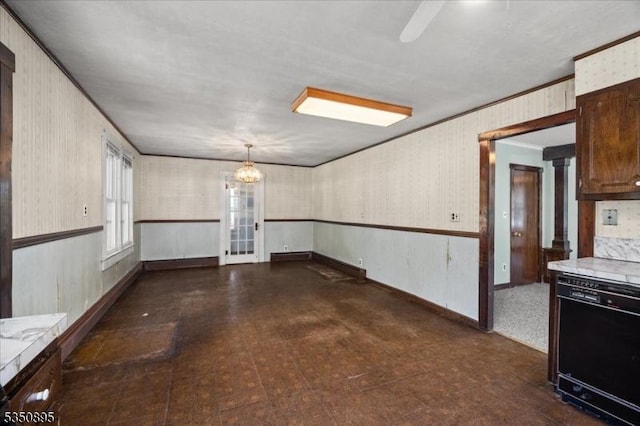 empty room with ornamental molding, tile patterned floors, wallpapered walls, and a chandelier