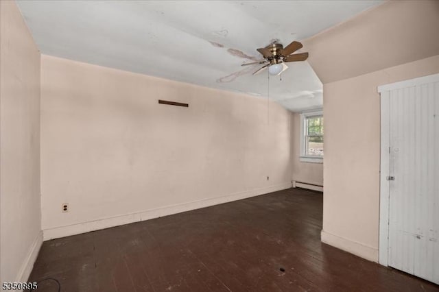 empty room featuring a baseboard heating unit, a ceiling fan, hardwood / wood-style floors, and baseboards