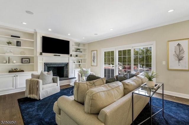 living room with crown molding, a fireplace with raised hearth, baseboards, and dark wood finished floors