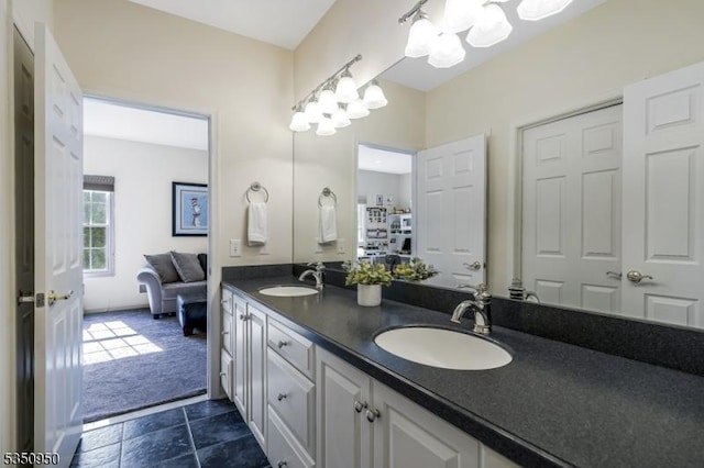 full bath with double vanity, an inviting chandelier, and a sink