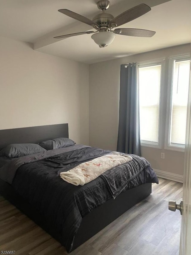 bedroom with baseboards, wood finished floors, and ceiling fan