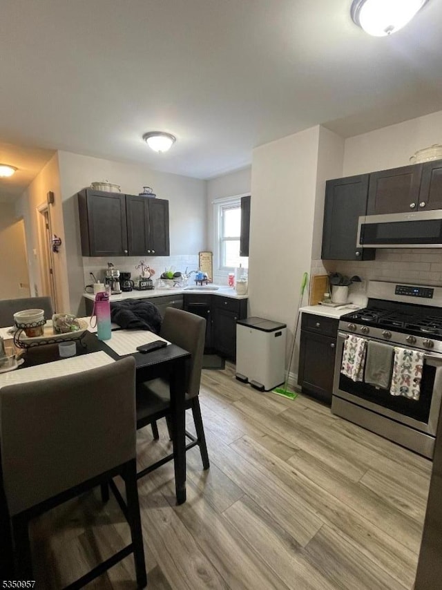 kitchen featuring backsplash, light countertops, and appliances with stainless steel finishes