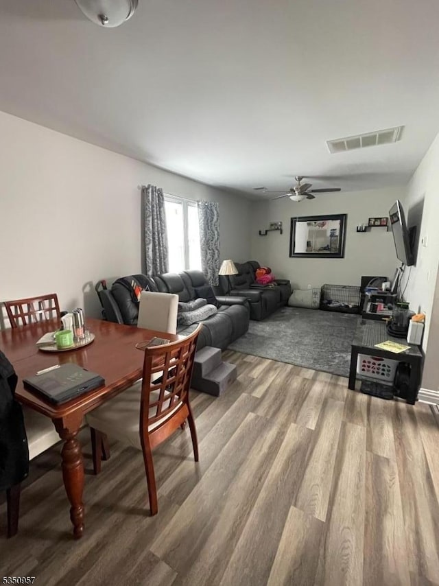 dining space featuring ceiling fan, wood finished floors, and visible vents