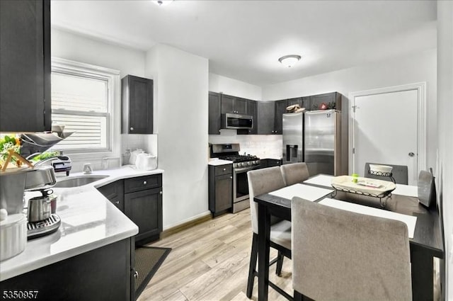105-107 Sanford Ave, Belleville Twp, NJ 07109 - kitchen featuring stainless steel appliances, backsplash, light countertops, light wood finished floors, and dark cabinets