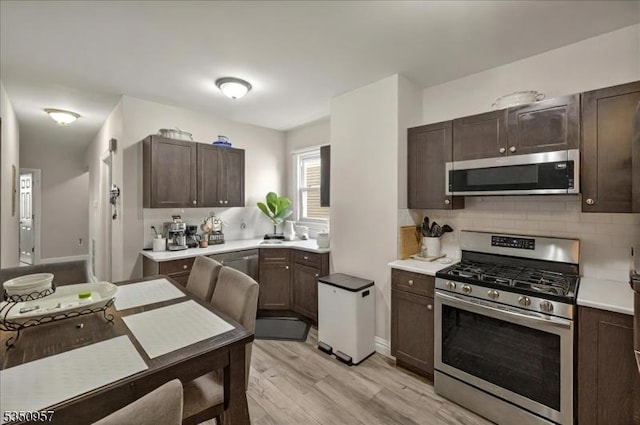 105-107 Sanford Ave, Belleville Twp, NJ 07109 - kitchen featuring stainless steel appliances, light countertops, dark brown cabinets, and light wood-type flooring