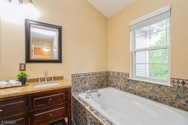 full bathroom featuring plenty of natural light, vanity, and a bath