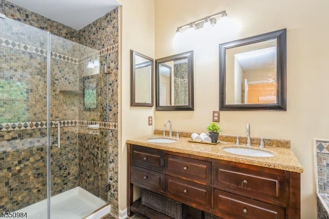 full bathroom with a shower stall and double vanity