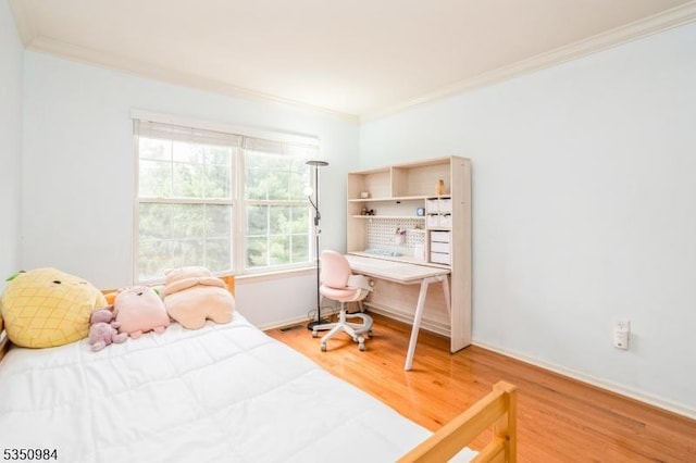 bedroom with crown molding, wood finished floors, baseboards, and an office area