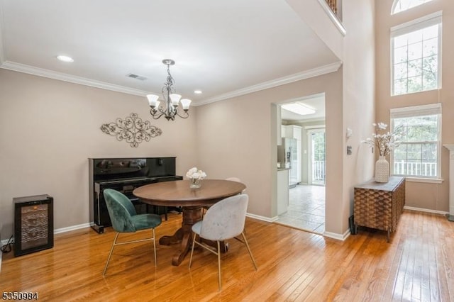 dining room with a chandelier, light wood-style flooring, baseboards, ornamental molding, and recessed lighting