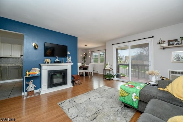 807 Eves Dr Unit 3P, Hillsborough Twp, NJ 08844 - living room featuring wood finished floors, a chandelier, a glass covered fireplace, and a baseboard radiator