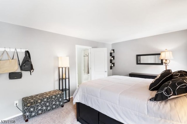 bedroom with carpet flooring, baseboards, and ensuite bath