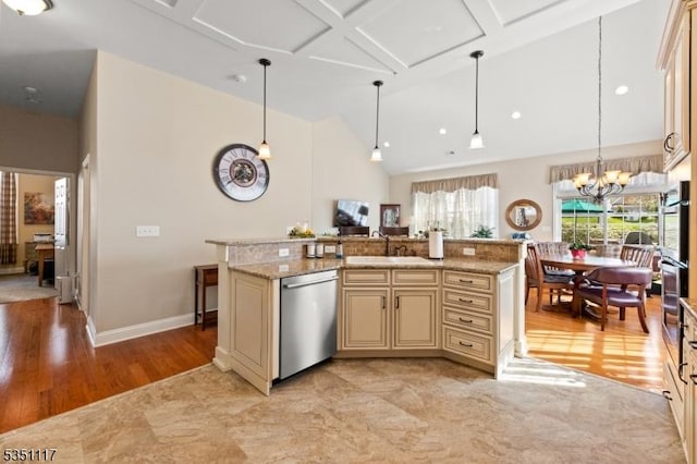 kitchen with high vaulted ceiling, cream cabinetry, a sink, decorative light fixtures, and stainless steel appliances