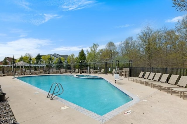 community pool with fence and a patio area