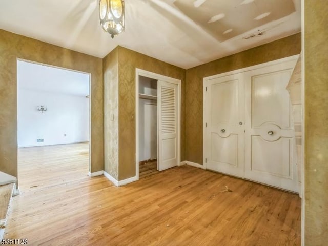 unfurnished bedroom with baseboards and wood finished floors