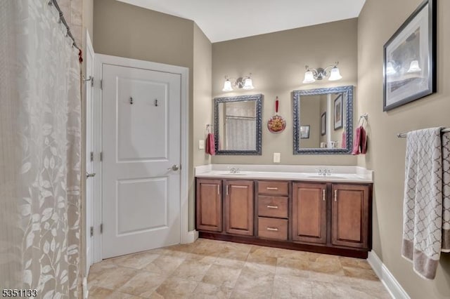 bathroom featuring double vanity and baseboards