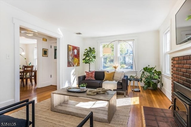 living area featuring visible vents and wood finished floors