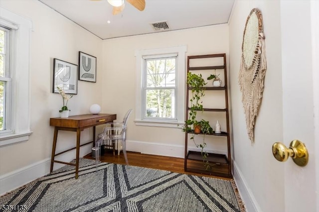 office featuring baseboards, ceiling fan, wood finished floors, and visible vents
