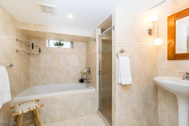 bathroom with visible vents, tiled shower, tiled tub, tile patterned floors, and a sink