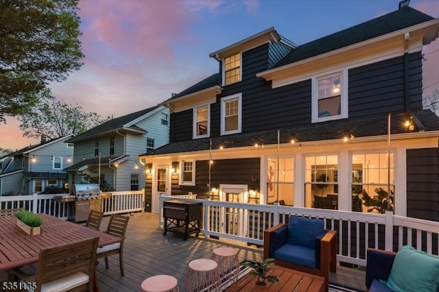 wooden deck with outdoor dining space and a grill