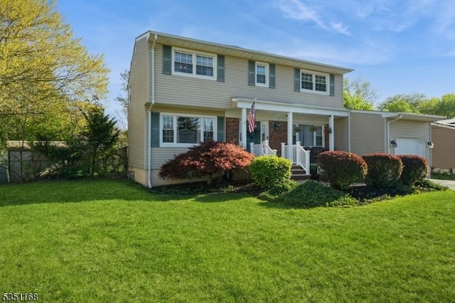 view of front of house with covered porch, a front yard, and a garage