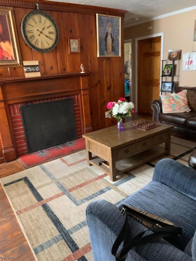 living area with crown molding, wood walls, light wood-style flooring, and a fireplace