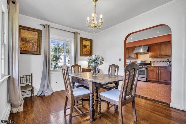 106 Anderson St, Raritan Boro, NJ 08869 - dining room with arched walkways, dark wood-style flooring, a chandelier, and crown molding