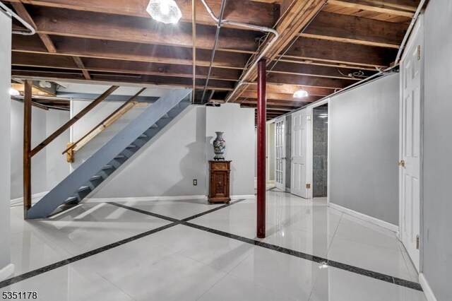 106 Anderson St, Raritan Boro, NJ 08869 - basement featuring inlaid floor details, baseboards, and stairway