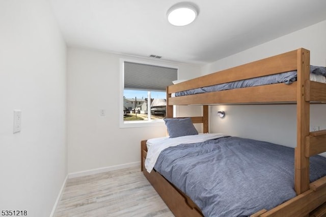 bedroom featuring visible vents, baseboards, and wood finished floors