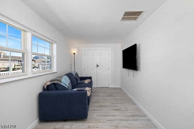 living area with light wood finished floors, baseboards, and visible vents