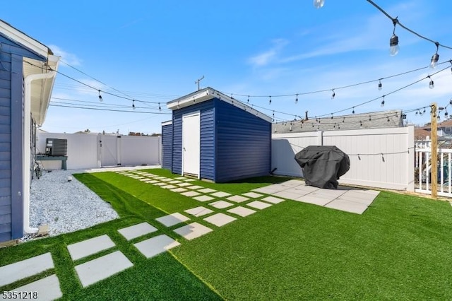 view of yard featuring a storage shed, a fenced backyard, an outdoor structure, a patio area, and a gate