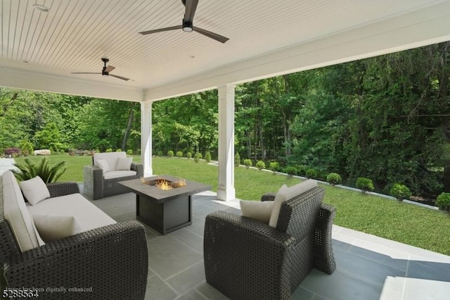 view of patio / terrace featuring a ceiling fan and an outdoor living space with a fire pit
