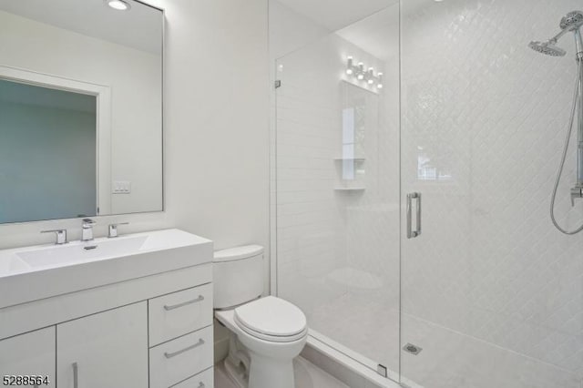 full bathroom with a shower stall, toilet, and vanity