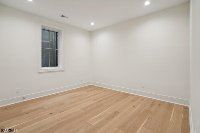 empty room with light wood finished floors, baseboards, and recessed lighting