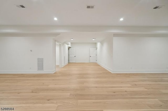 spare room with baseboards, light wood-style floors, visible vents, and recessed lighting