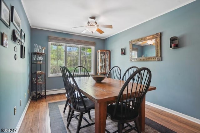 dining room with a ceiling fan, ornamental molding, baseboards, wood finished floors, and a baseboard radiator