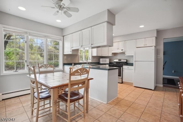 kitchen with white appliances, dark countertops, white cabinetry, under cabinet range hood, and ceiling fan