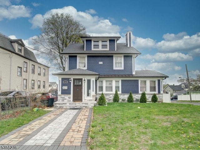 traditional style home with a front yard, stone siding, fence, and a chimney