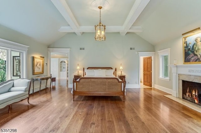 bedroom featuring wood finished floors, a high end fireplace, a chandelier, and baseboards